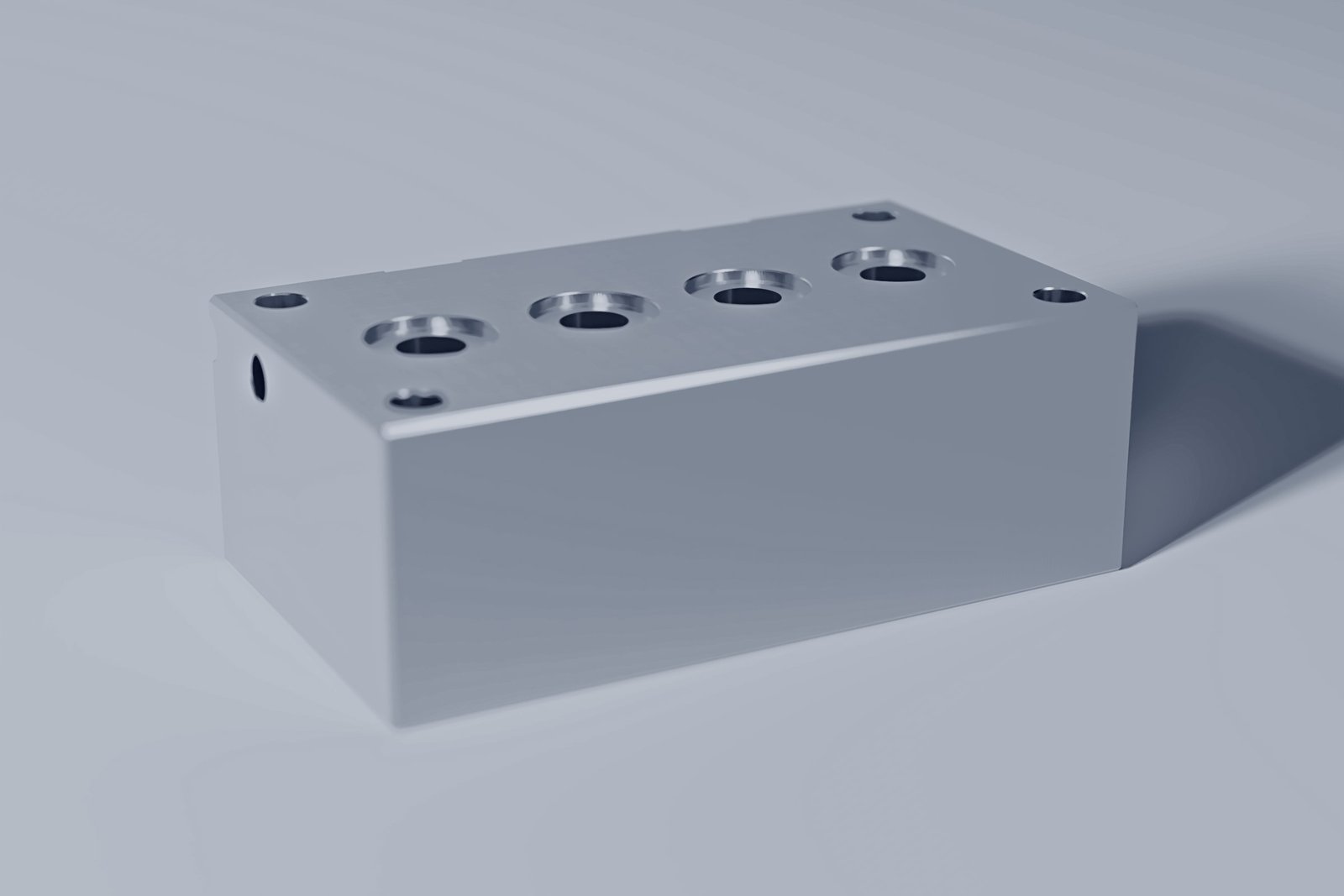 Ein geschliffener Hydraulik-Verteilerblock aus Stahl mit plangesenkten Anschlüssen auf zwei Seiten.