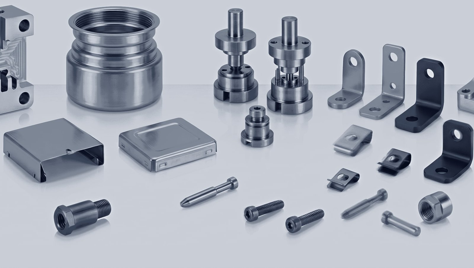 A wide range of machined and stamped parts — a large threaded steel sleeve, valve-type assemblies, sheet-metal enclosures, brackets, clips, screws and bolts.